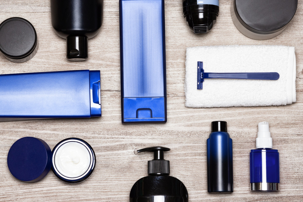 travel grooming essentials in blue, white, and black such as shampoo and shaver