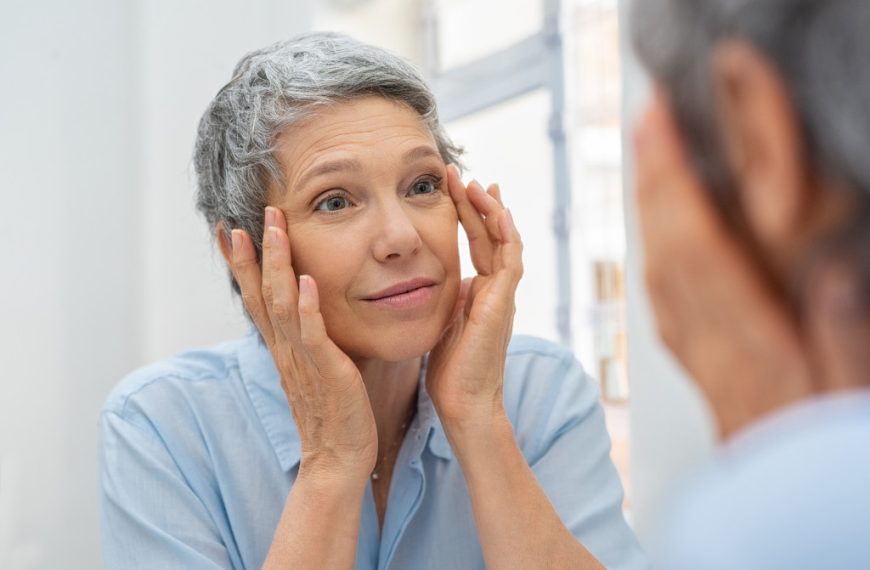 aging woman looking at skin